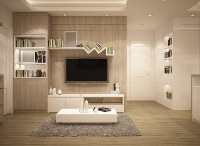 A modern living room featuring white furniture and a flat-screen television on the wall